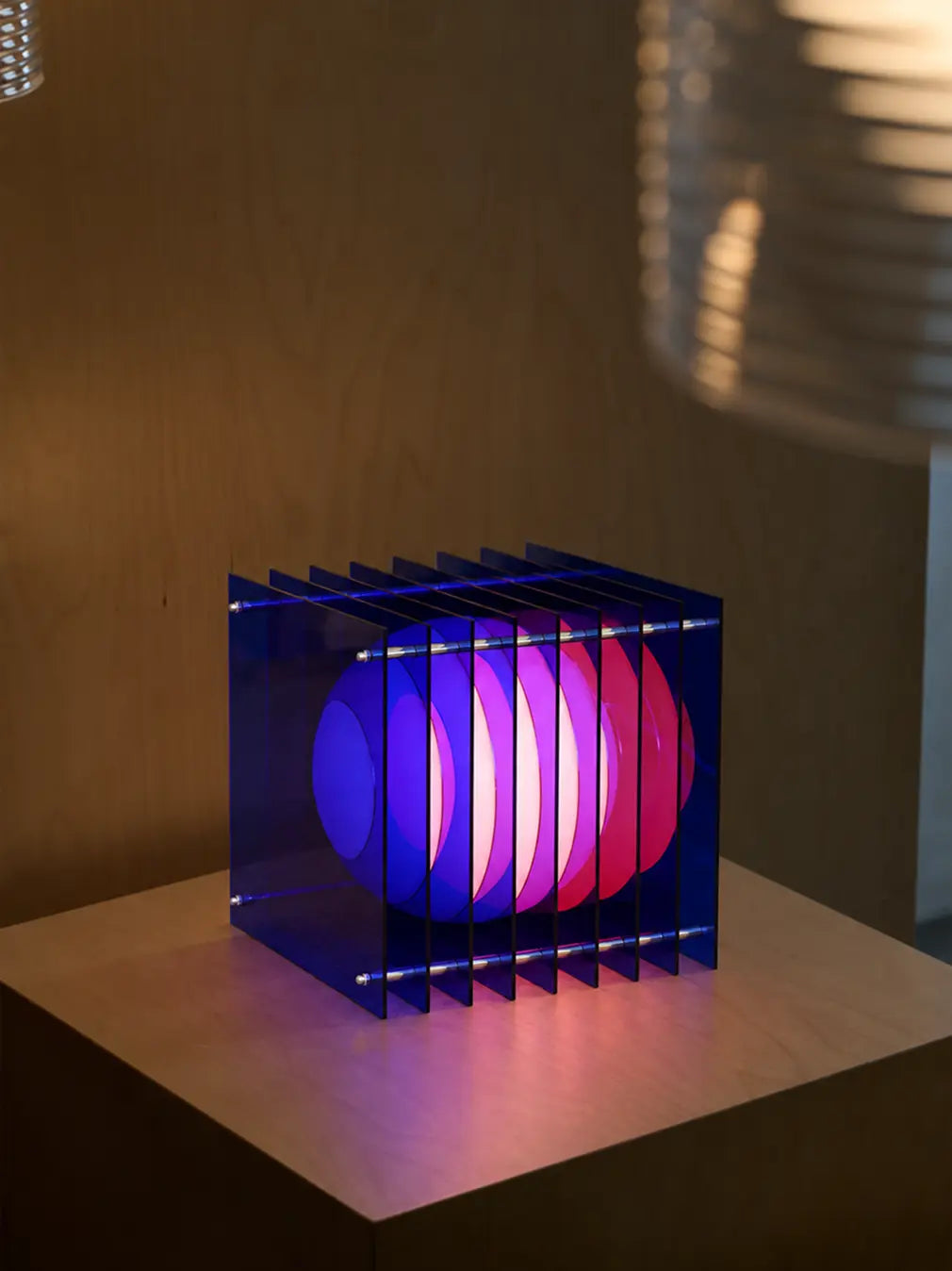 Lop Blue Table Lamp with layered acrylic and soft pink glow in a modern interior