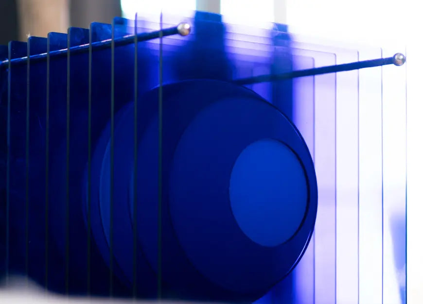 Close-up of layered acrylic design on modern blue table lamp with opal globe