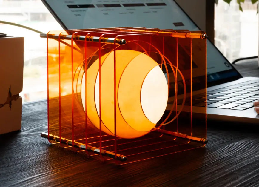 Lop portable LED table lamp beside laptop creating warm desk lighting