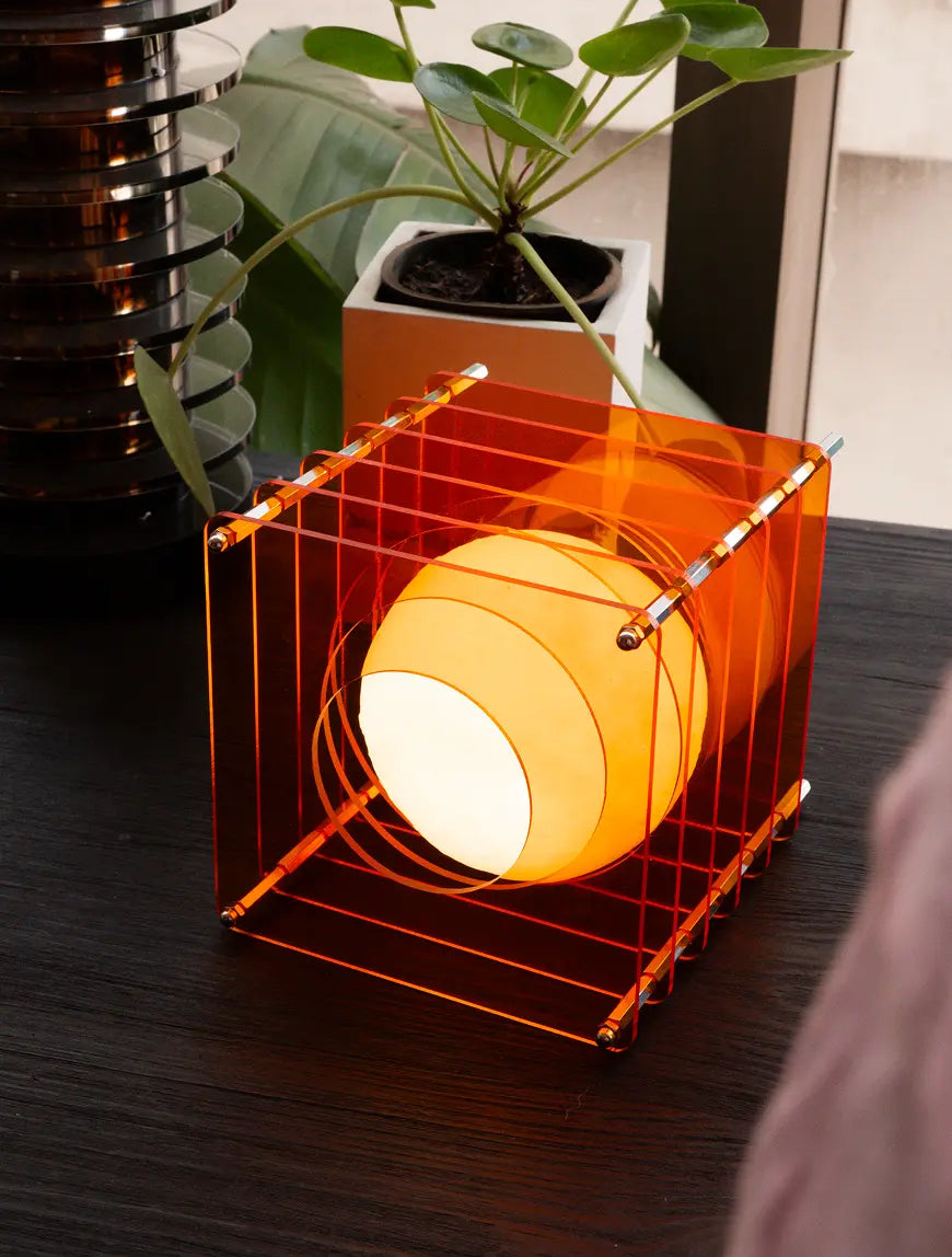 Modern Lop portable table lamp with orange acrylic panels on wooden desk
