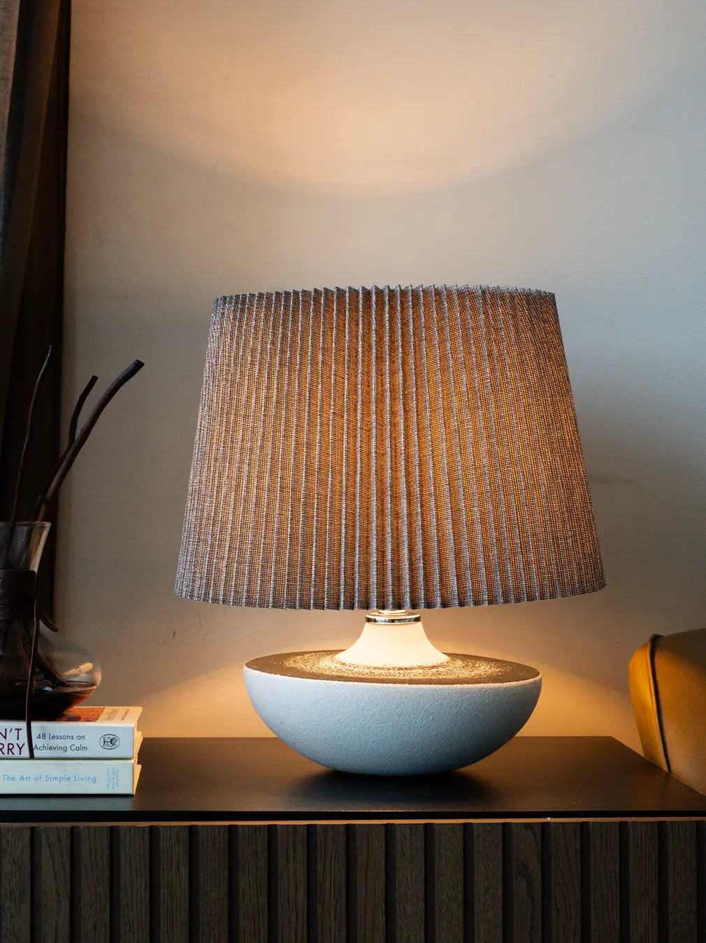 White ceramic table lamp with textured shade on a wooden surface