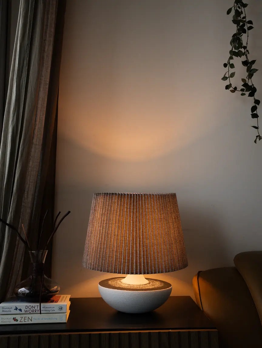 Decorative Table lamp on a table with a warm glow in a softly lit room.