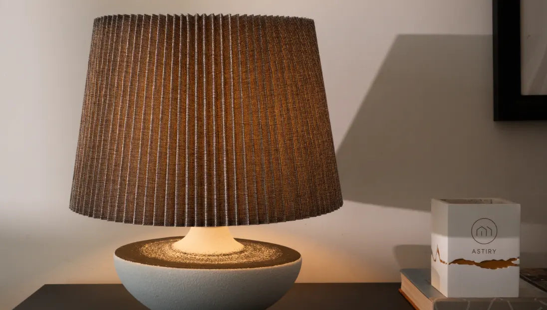 Modern Wabi Sabi ceramic table lamp with a textured brown shade on a dark surface, next to a white ceramic candle