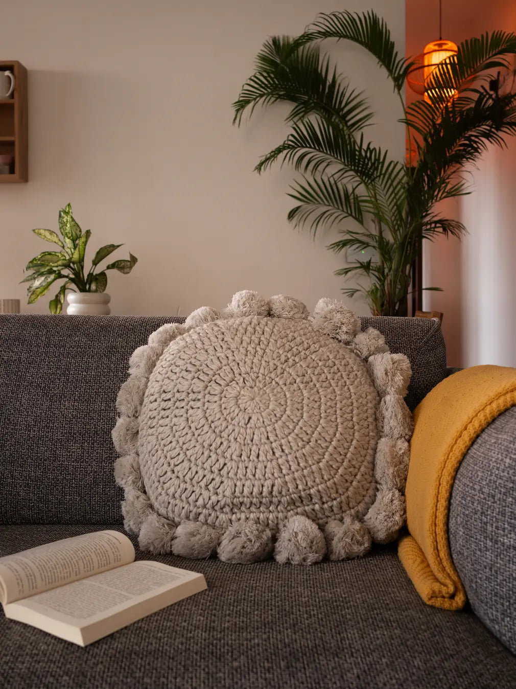 Gharko's Grey round knitted cushion with tassels styled on sofa – perfect sofa cushion