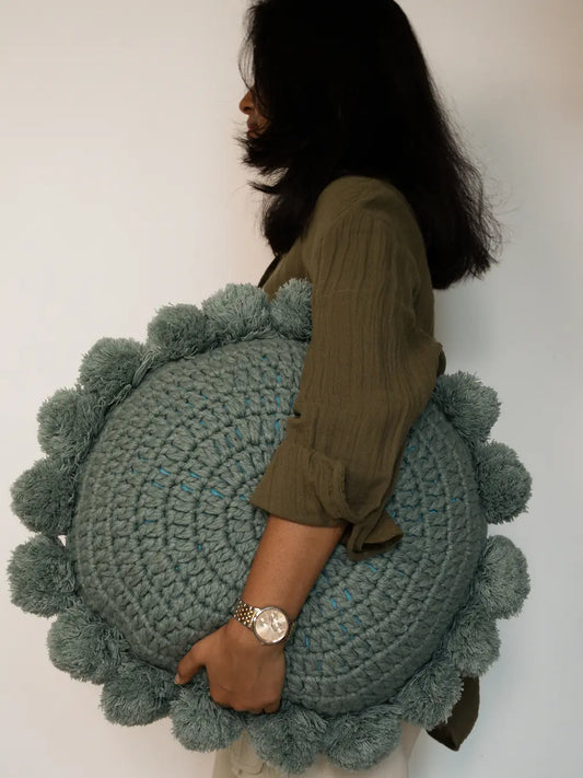Woman holding Nimbus Round Cushion Turquoise Blue decorative cushion
