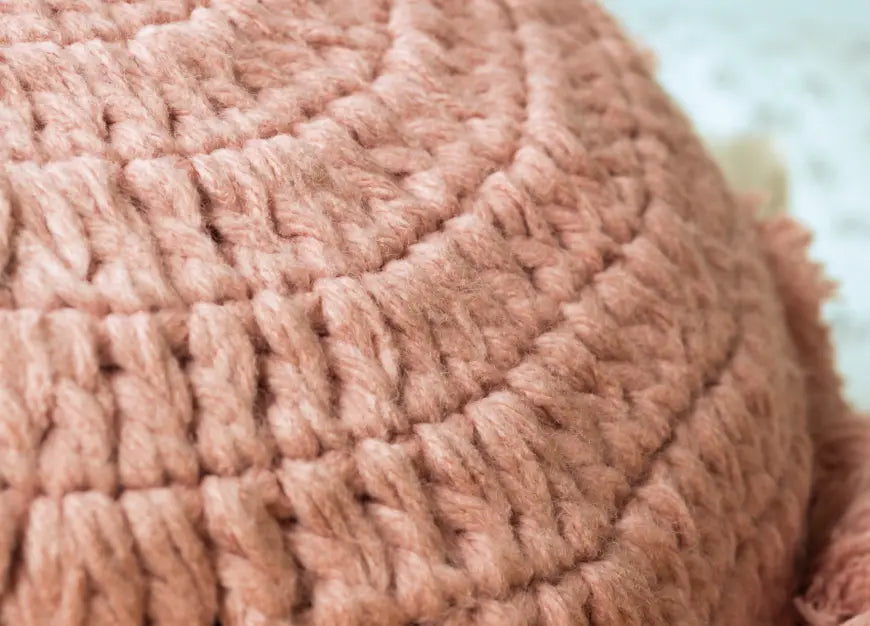 Close-up of Gharko's pink knitted decorative cushion