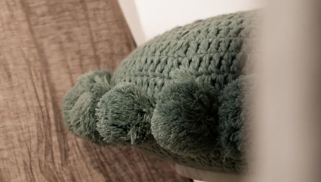 Close-up of turquoise blue fluffy round cushion with tassel edges