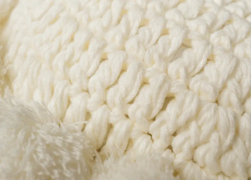Close-up of white yarn with a textured pillow