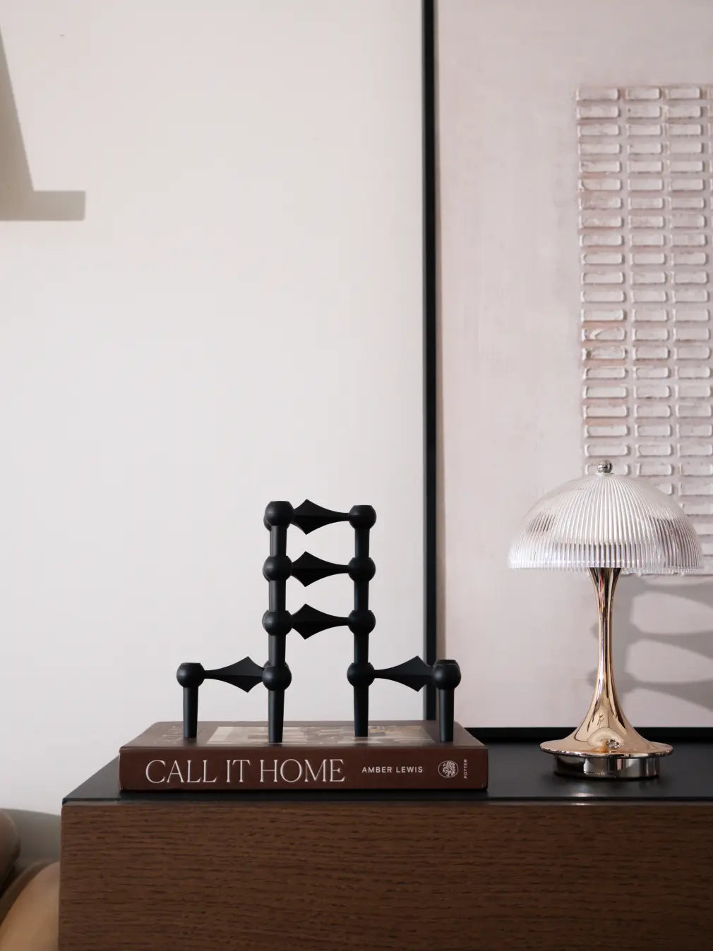 Modern Node black candle holder styled on bedside table with ambient lighting
