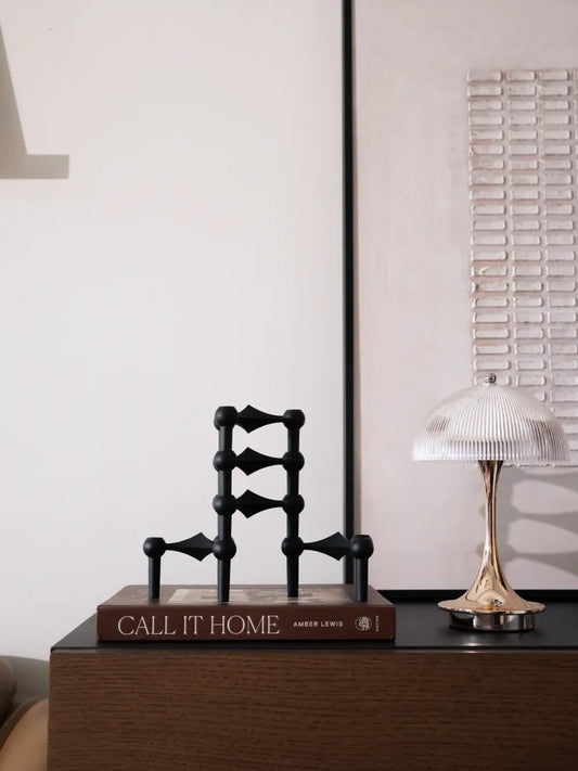Modern Node black candle holder styled on bedside table with ambient lighting