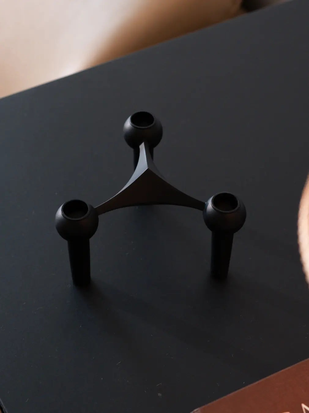 Matte black taper candle holder with sculptural geometric form