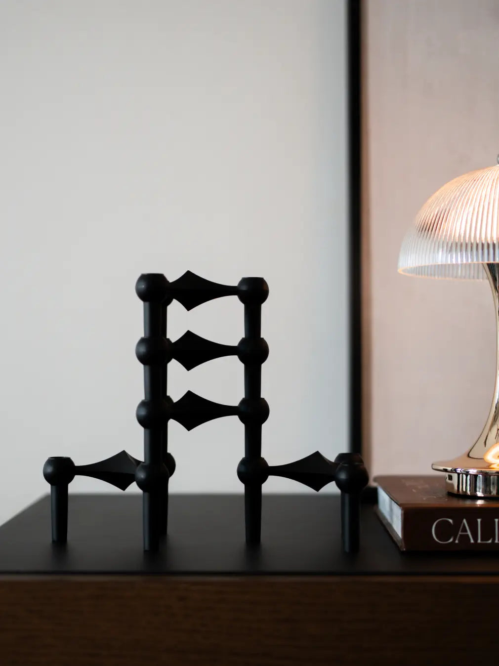 Sculptural matte black candle holder for modern shelf and console styling