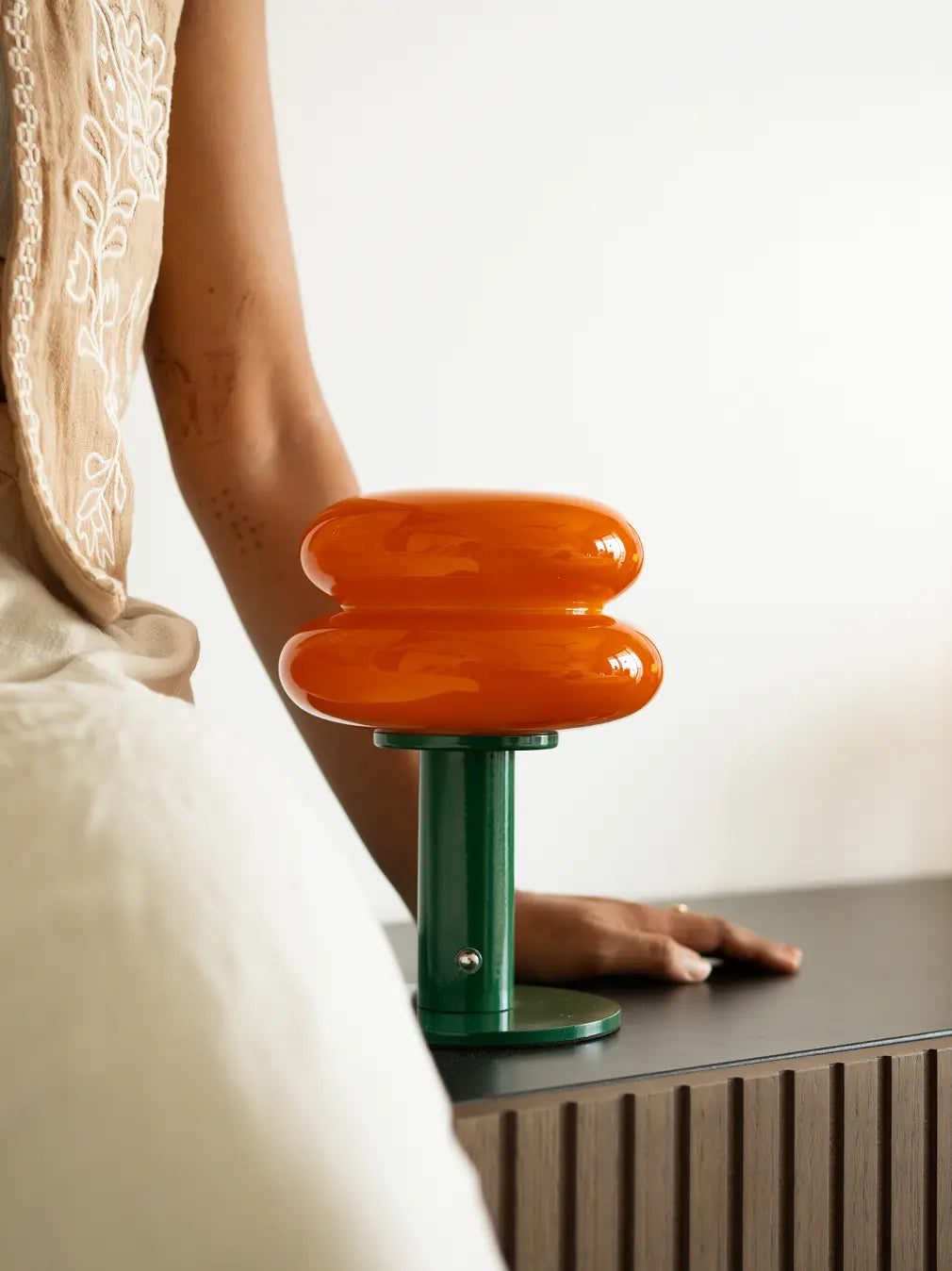 Modern portable lamp with orange glass shade and touch control
