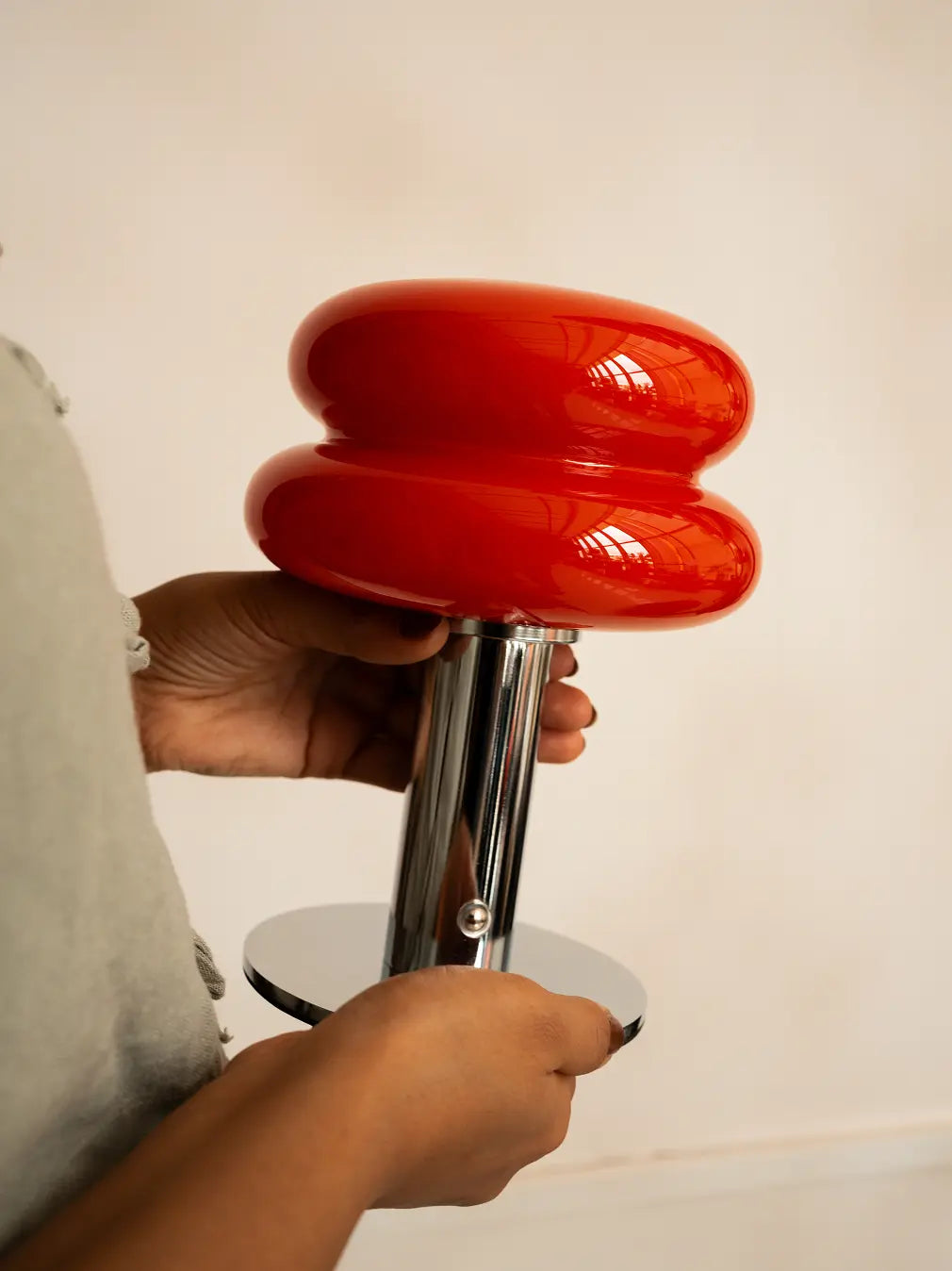 Close-up of Orbit Red portable table lamp with red glass shade and chrome base
