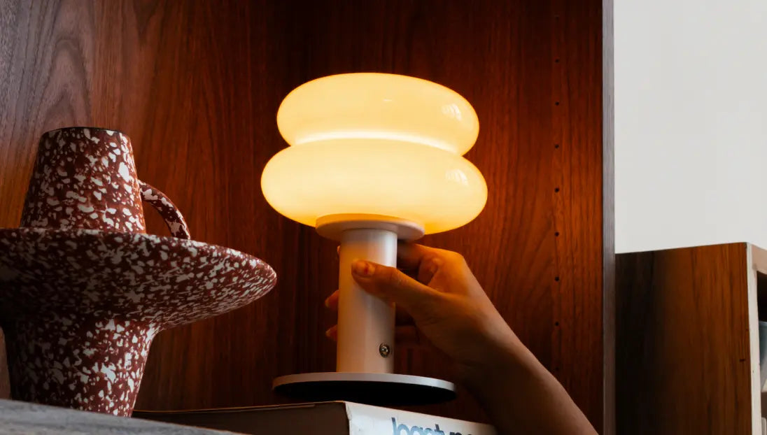 Portable designer table lamp with warm light and sculptural glass silhouette