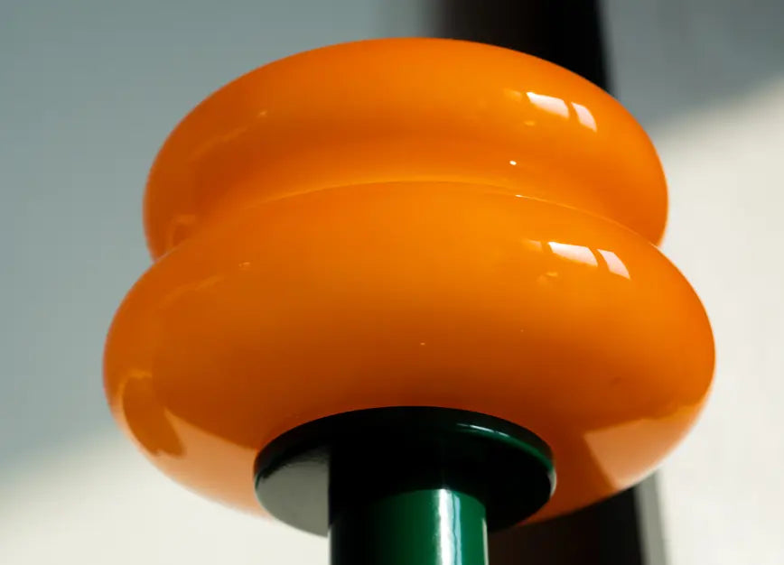 Close-up of orange glass shade on modern cordless rechargeable lamp