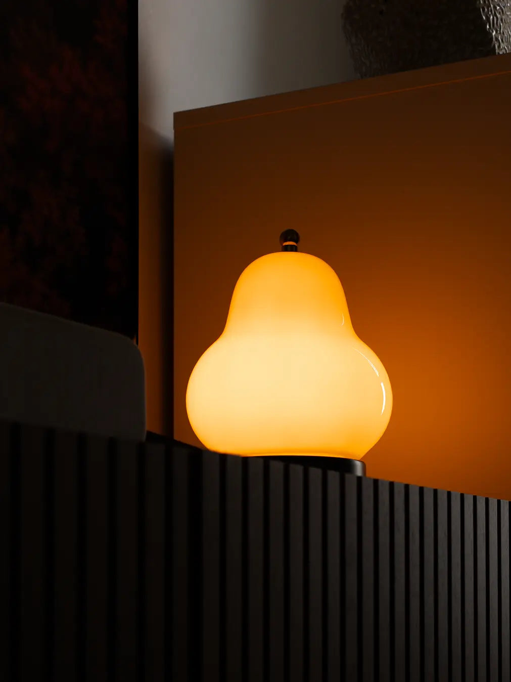 Glowing yellow Pear Lamp on a dark background