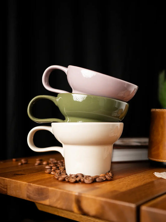 Pico ceramic coffee mug stacked in soft pastel tones on wooden table with coffee beans
