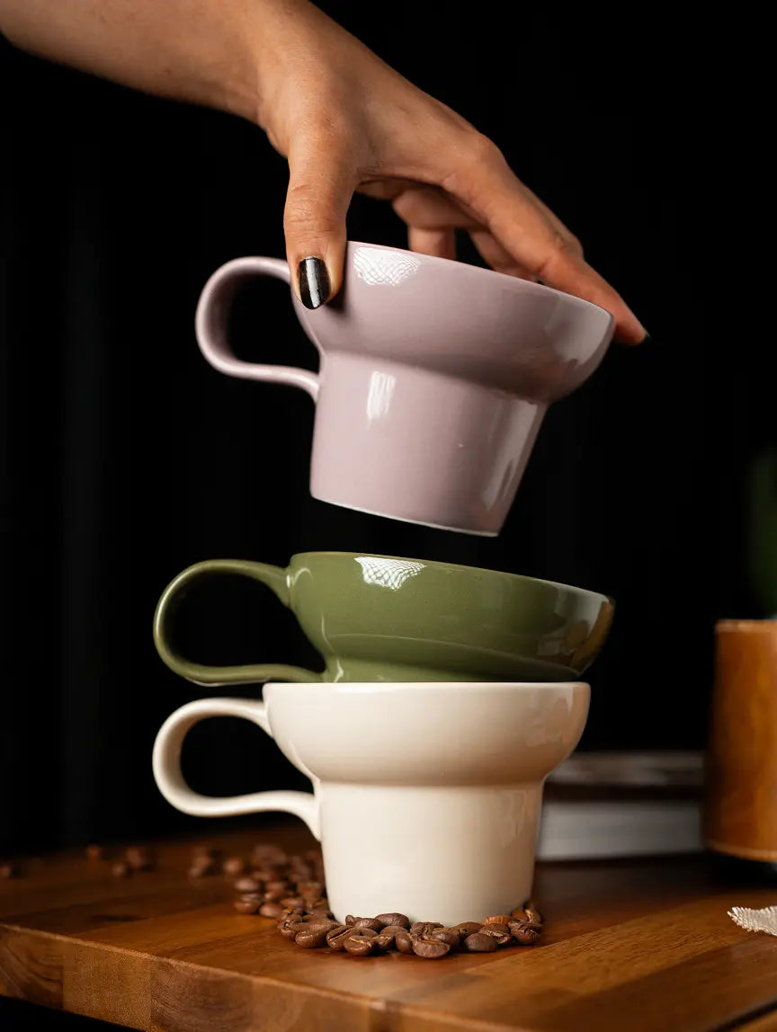 Pico ceramic coffee mug stacked in pastel shades on wooden table with coffee beans