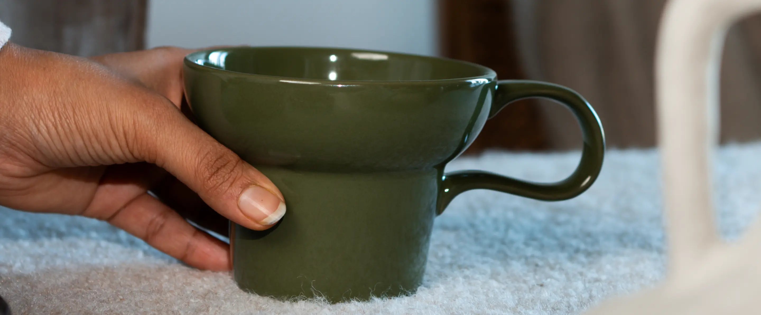 Close-up of Pico ceramic coffee mug handle and smooth glazed finish in green