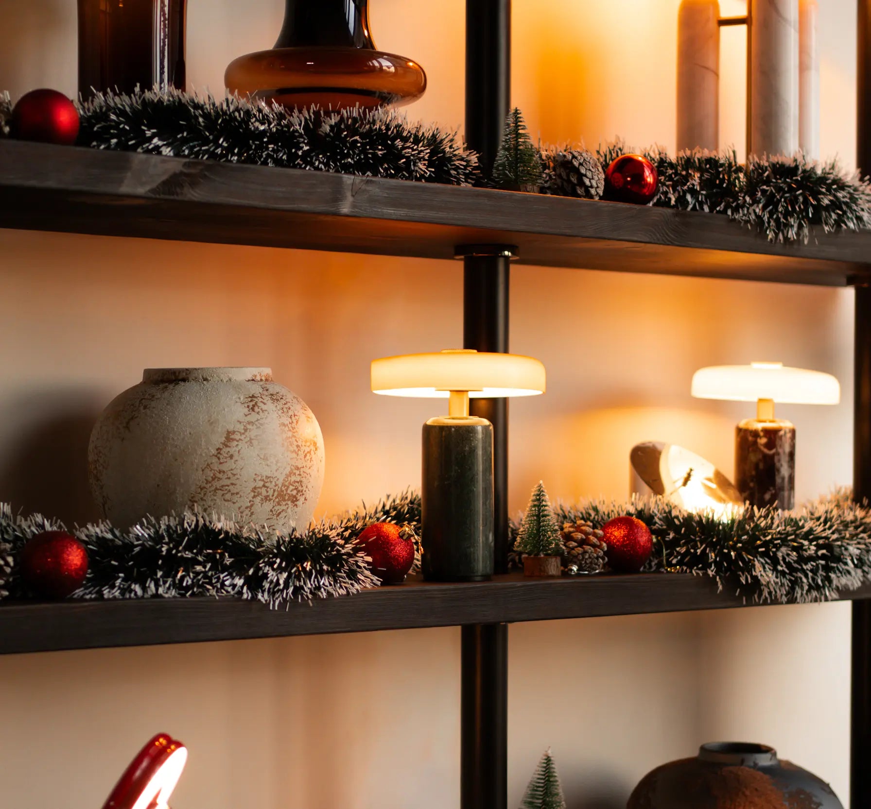 Decorative shelves with festive decorations, including tinsel, ornaments, and a small lamp.