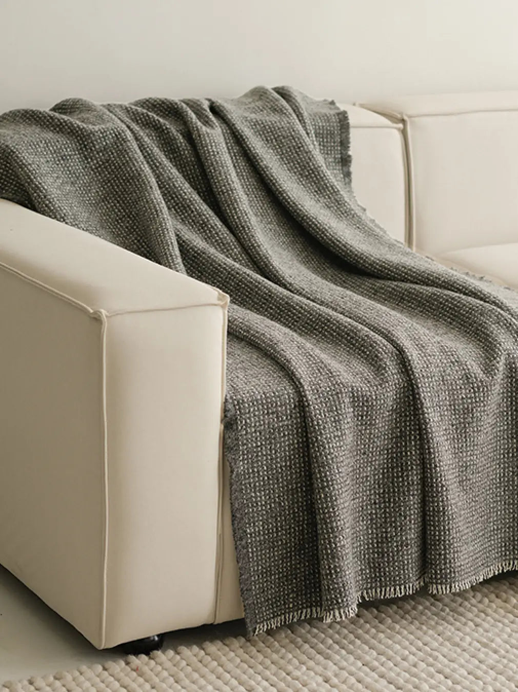 Slate Angora wool throw blanket draped over white sofa in modern living room