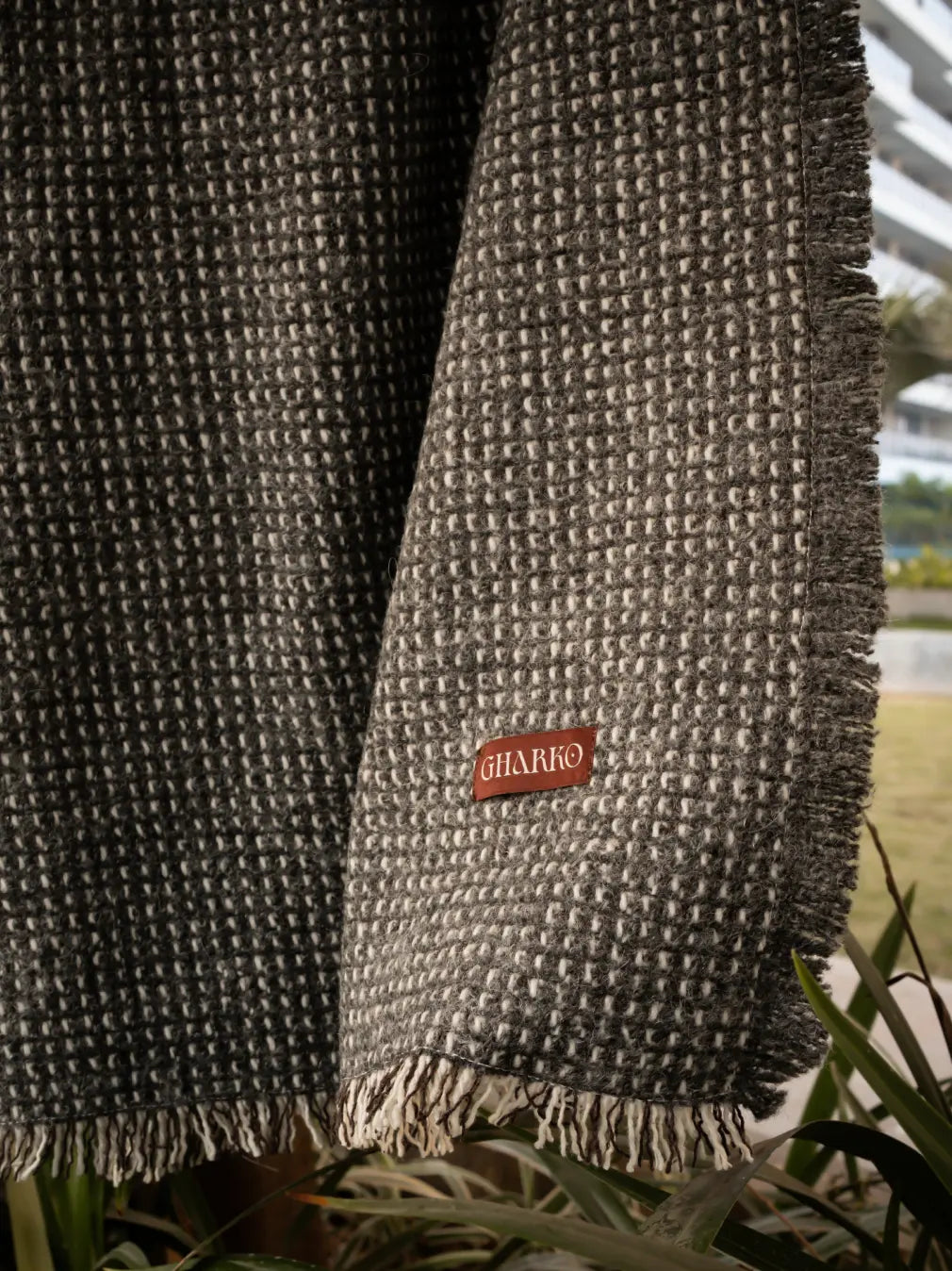 Close-up of Slate Angora throw blanket with textured jacquard weave and tassel edge