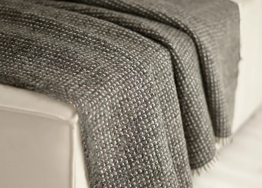 Slate Angora wool throw blanket draped over sofa with rich woven texture