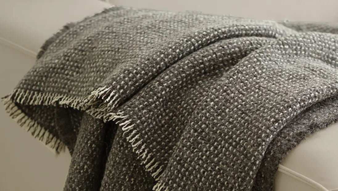 Textured Slate Angora throw blanket with tassel edges styled on modern sofa