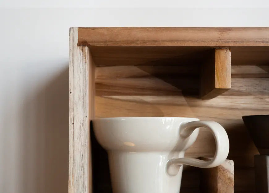Close view of coffee mug on teak wood wall mounted cup shelf organizer