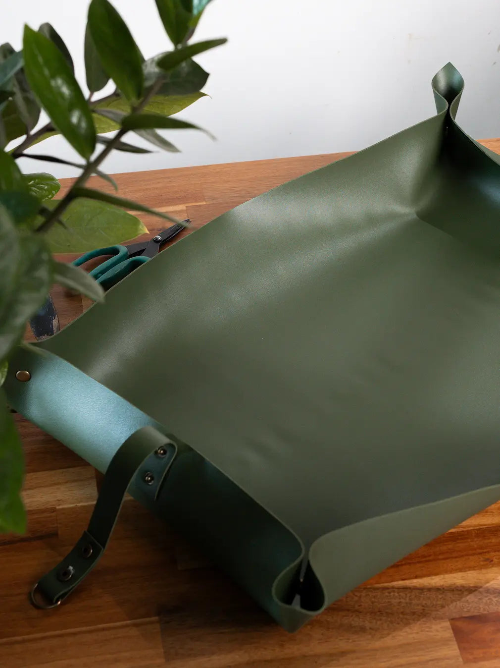 Solum Olive potting mat on table, waterproof surface for indoor plant repotting