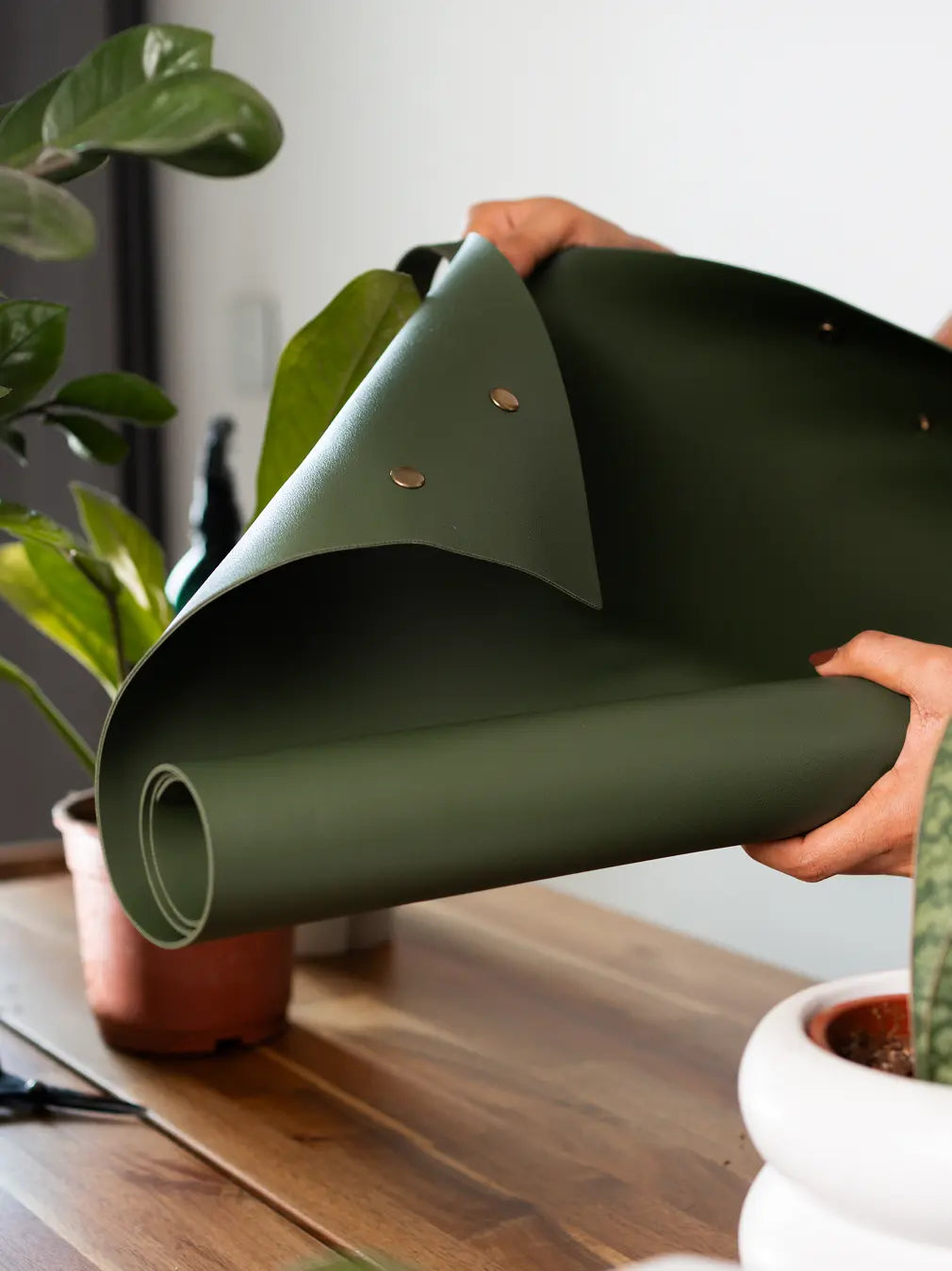 Unfolding Solum Olive potting mat showing snap edges and flexible design