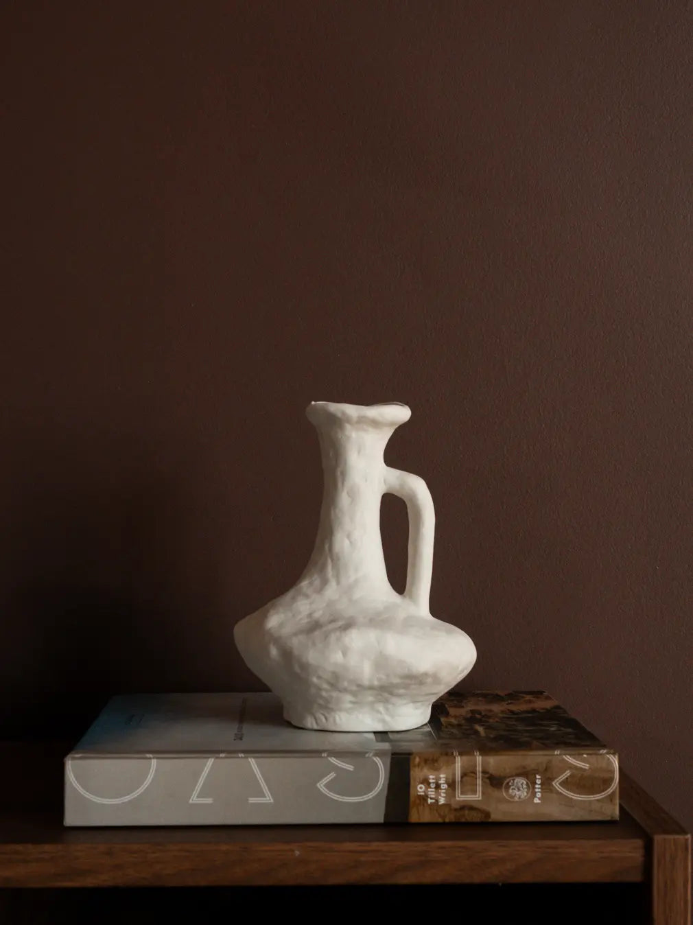 Suki Classic Ceramic Vase styled on books, featuring organic white texture and sculptural porcelain form.