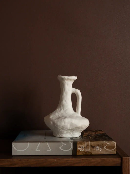 Suki Classic Ceramic Vase styled on books, featuring organic white texture and sculptural porcelain form.