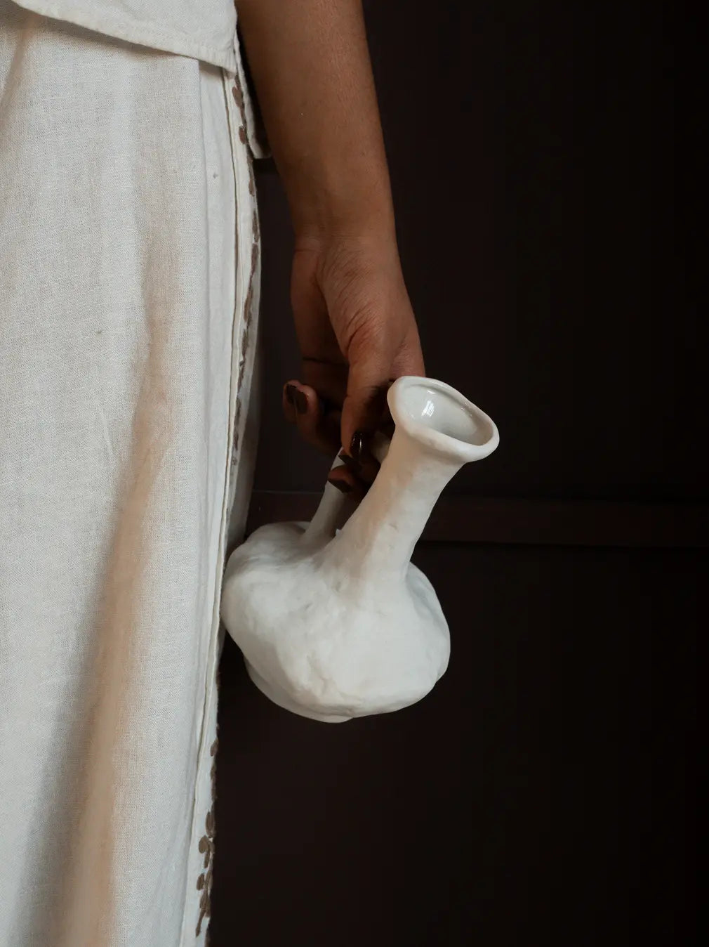 Hand holding Suki Classic Ceramic Vase showing ergonomic handle and textured porcelain finish.