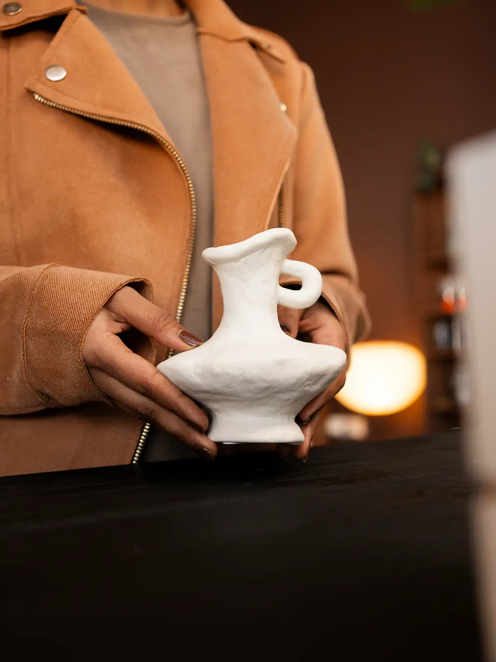 Handheld Suki Mini Ceramic Vase showing its sculptural form, organic texture, and premium white porcelain build.