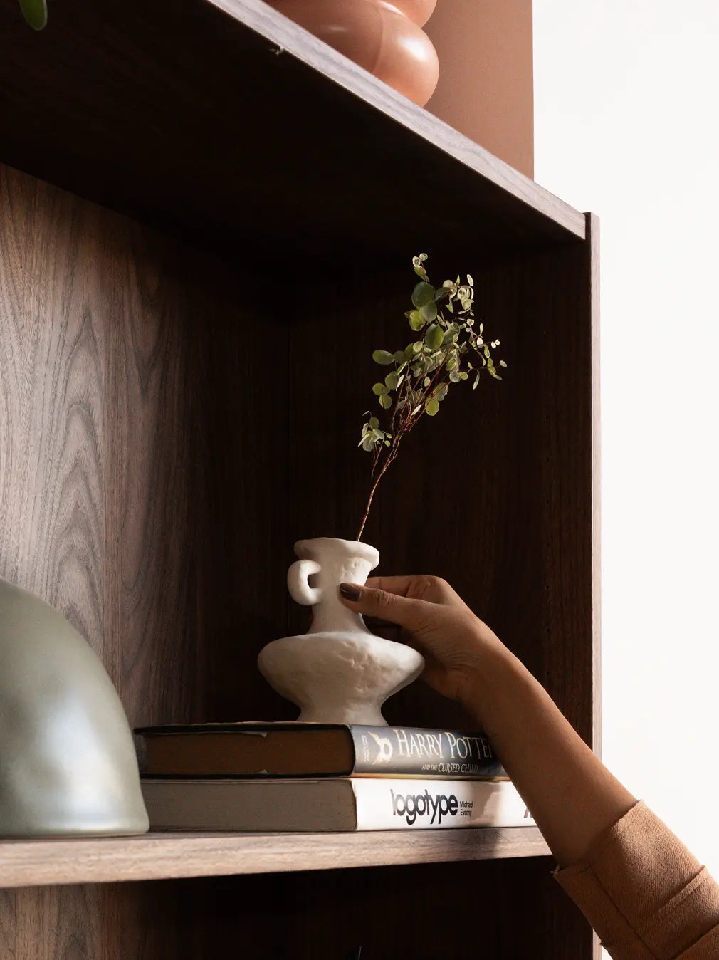 Suki Mini Ceramic Vase placed on a bookshelf, styled as a modern decorative vase with natural stems.
