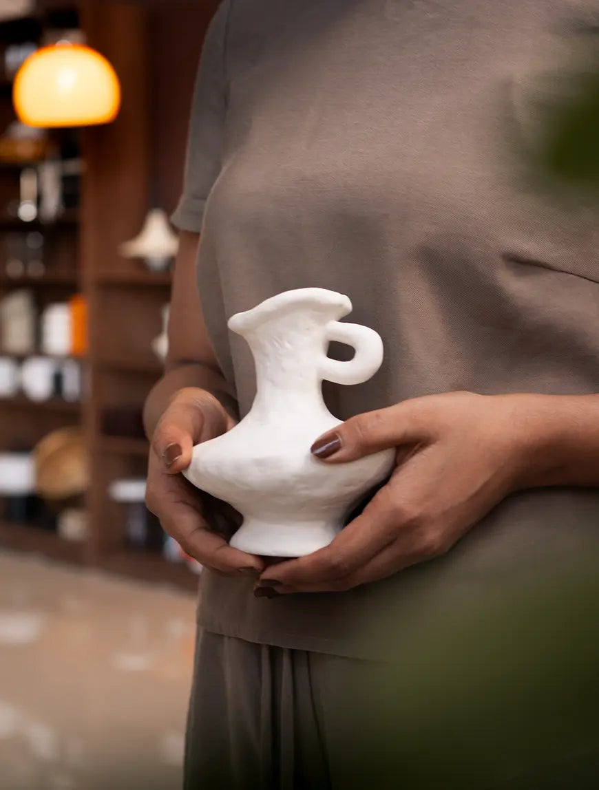 Suki Mini Ceramic Vase held at waist level, showcasing its organic shape and premium porcelain finish.