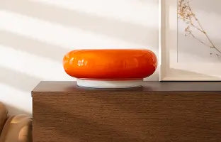 Decorative orange lamp on a wooden surface with a blurred background