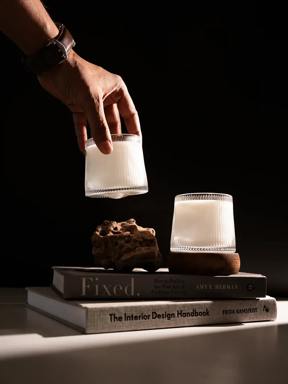 Hand holding a Telosma Cordata Glass Aromatherapy Candle, highlighting its fluted glass design and warm glow.