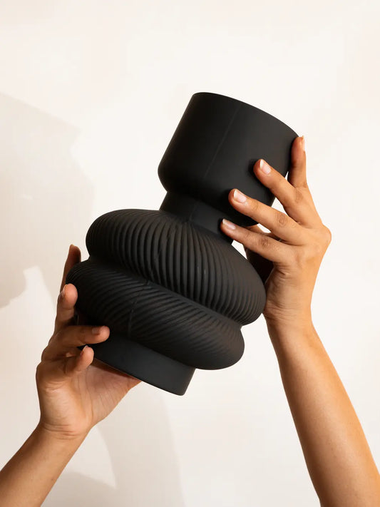 Hands holding Torus Glass Vase in premium matte black modern flower vase for home decor.