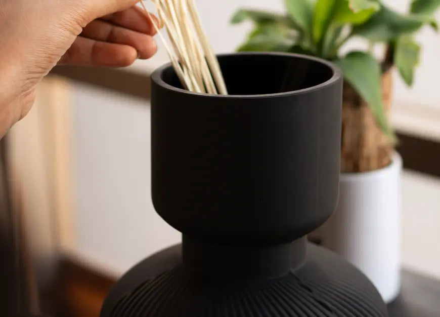 Close-up of Torus Glass Flower Vase in matte black with wide top for arranging stems.