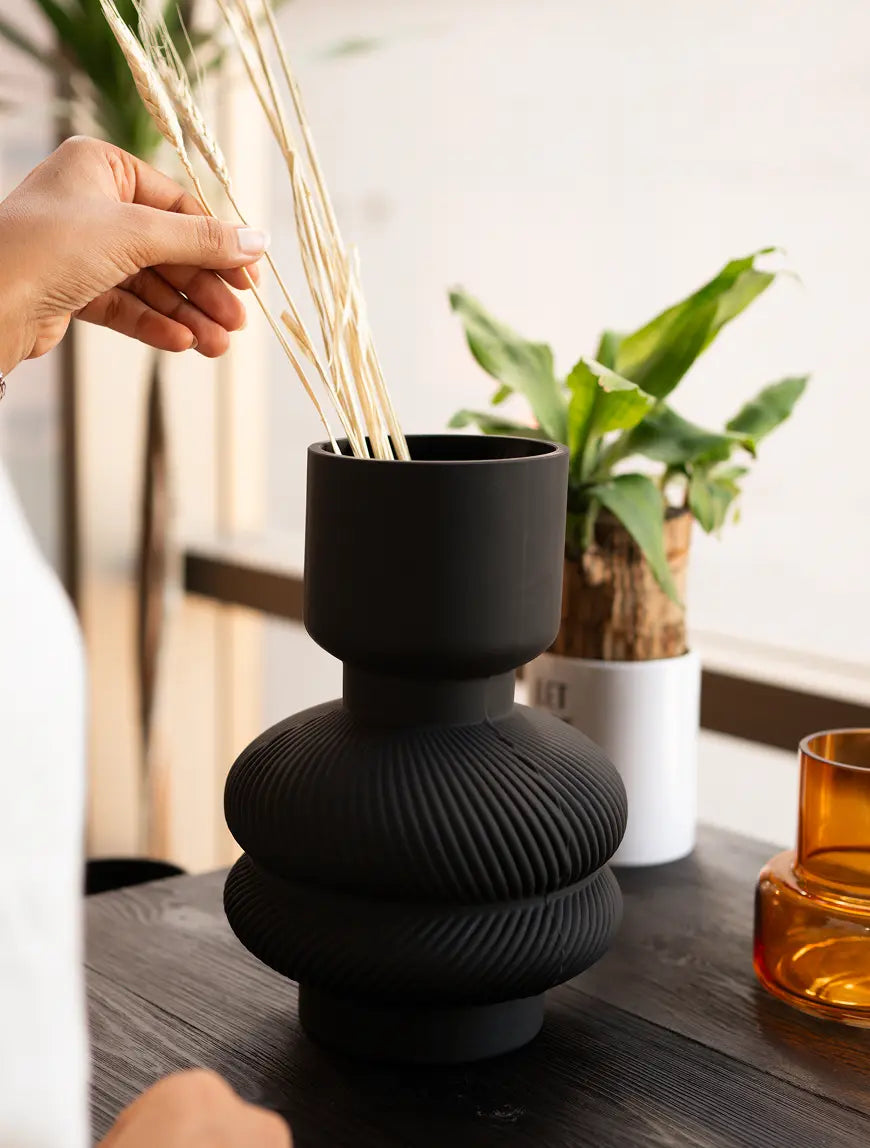 Torus Glass Vase styled with dry stems as a premium modern black glass flower vase.