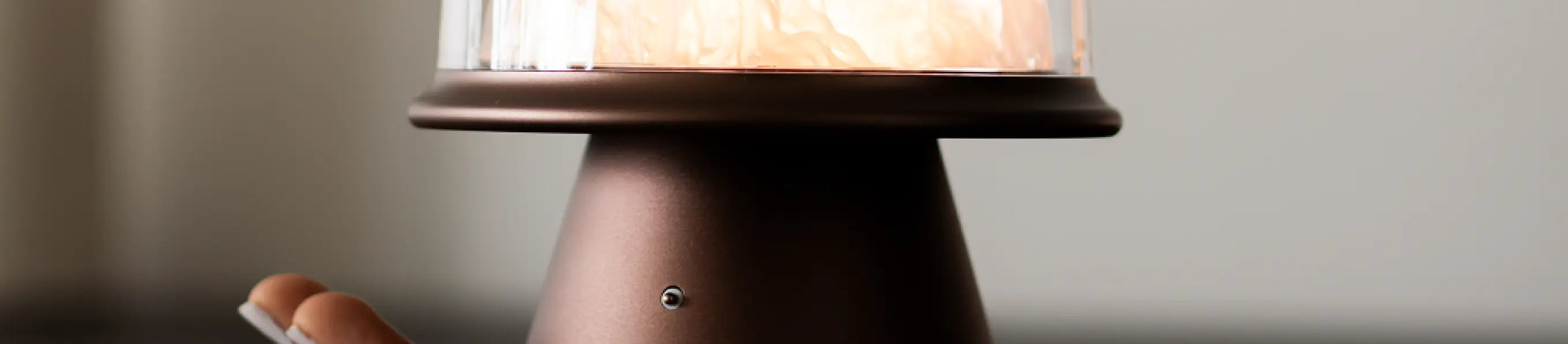Touch lamp with a glass dome with a warm glow on a neutral background