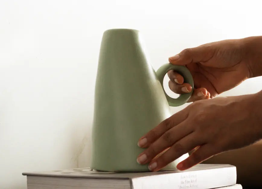 Placing Gharko's premium ceramic vase on books, stylish vase for home décor.
