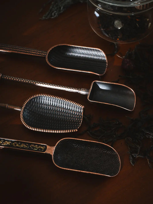 Set of four Vintage Spoons displayed on a dark wooden surface, featuring intricate engravings.