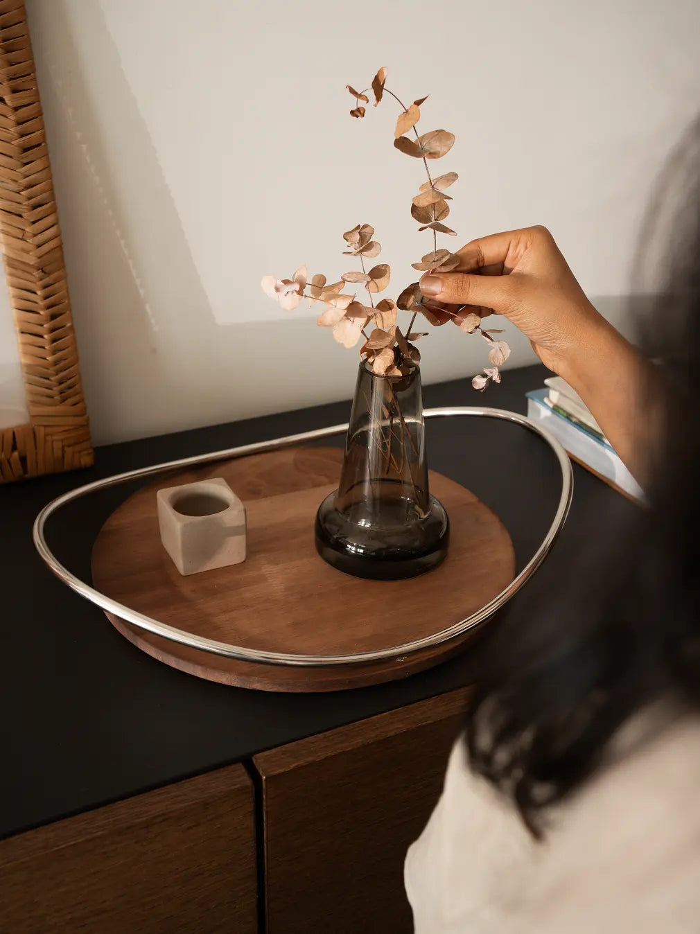 Wooden tray styled with glass vase and decorative accent on console