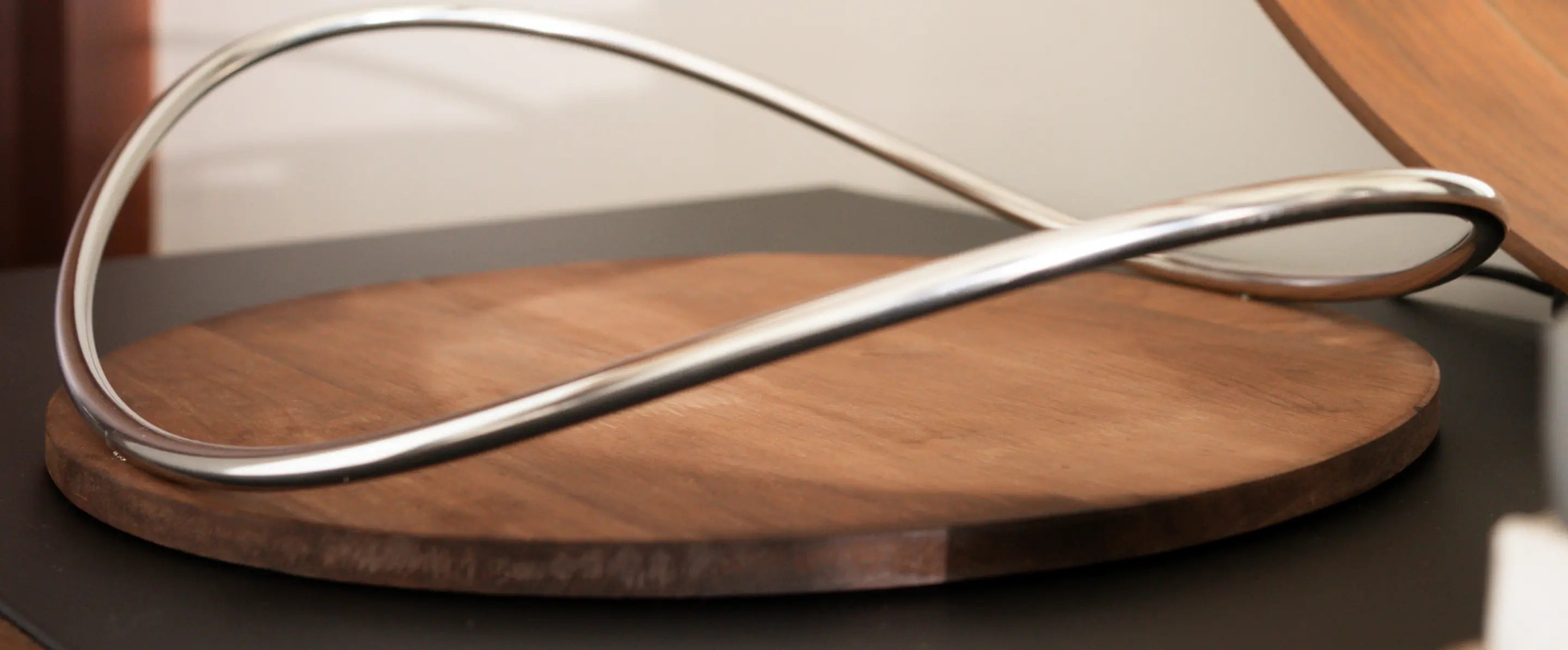 Sculptural metal handle detail on modern pine wood tray