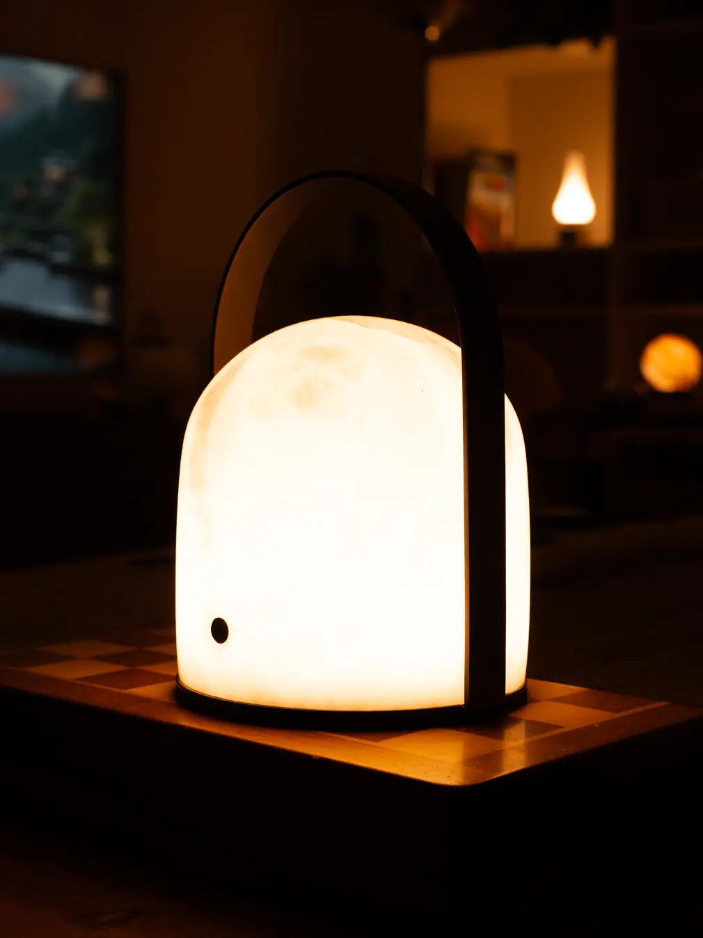 Arcus marble table lamp glowing warmly as ambient lighting on a table