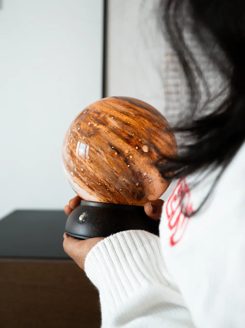 Cosmo portable glass table lamp held by hand showing its compact design